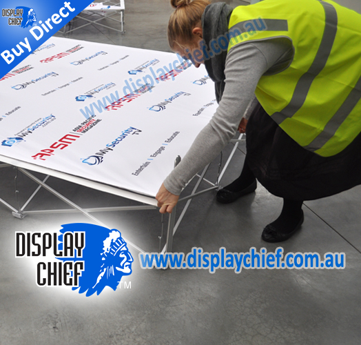 Fitting and tightening adjusting the fabric printing for the sign wall ready to stand upright
